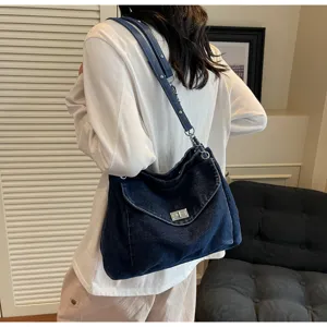 Vue détaillée d'un sac à bandoulière en denim délavé bleu foncé avec fermoir métal