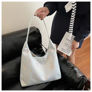 Grand sac cabas bleu clair de style néochinois avec de fines broderies dorées.