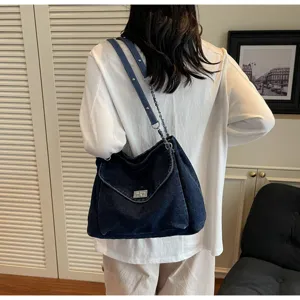 Vue arrière d'un sac cabas en denim délavé bleu marine avec chaîne argentée et fermoir