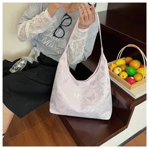 Cabas rose brodé de papillons de style chinois, porté par un mannequin dans un escalier
