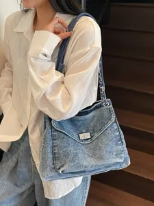 Sac à bandoulière en denim délavé avec chaîne et fermoir en argent pour femmes.