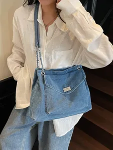 Sac fourre-tout élégant en denim délavé avec chaîne argentée et fermoir pivotant quotidien.