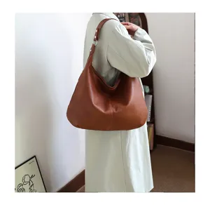 Large brown soft leather hobo bag worn over the shoulder for a chic commuter look