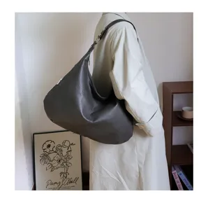 Side view of large vintage soft leather hobo tote bag worn on shoulder for style