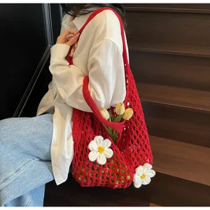 Detalle de estilo de vida de un bolso de malla de ganchillo rojo decorado con flores blancas