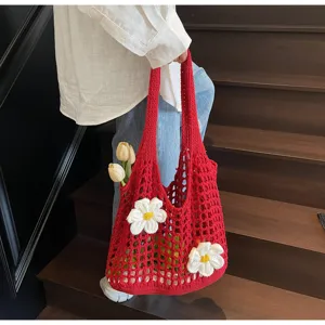 Detalle de bolso de red rojo con adornos de flores blancas tejidas a mano