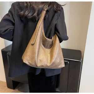 Detailed close-up of the vintage brown leather hobo bag worn with a chic black blazer.