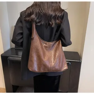 Back view of a woman wearing a stylish brown vintage textured leather tote bag