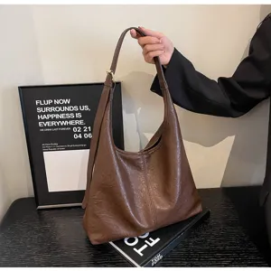 Vintage brown distressed leather hobo bag for women in a lifestyle studio setting