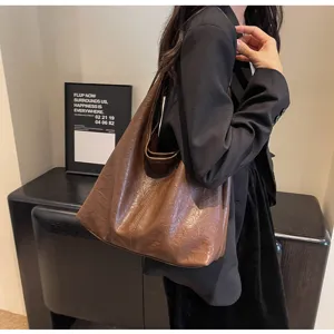 Detailed view of a vintage brown textured leather hobo shoulder bag worn by a model
