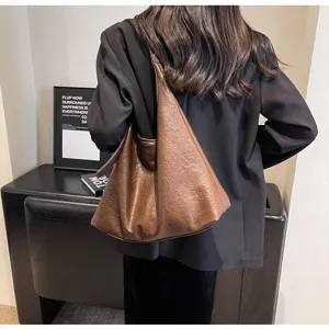 Vintage brown leather hobo bag for women worn by a model in a commute setting