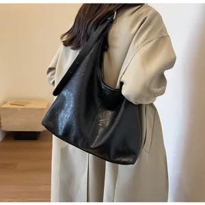 Black vintage leather hobo bag with textured finish shown on shoulder for daily commute