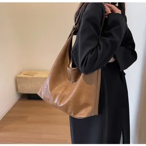 Vintage brown leather hobo tote bag shown worn on a model's shoulder for daily use