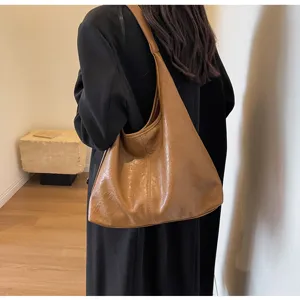 Vintage brown glossy leather hobo bag for women in lifestyle setting
