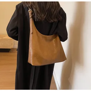 Lifestyle shot of a model wearing a vintage brown leather tote shoulder bag with a black coat