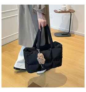Black quilted puffer tote bag for women, large capacity winter commuter handbag with cute plush charm.