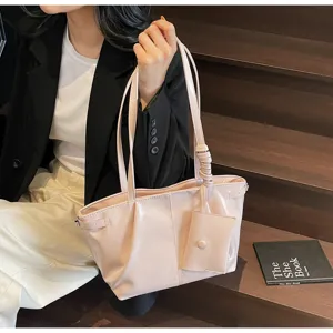 Detailaufnahme eines großen, rosa weichen Leder-Schulterbeutels, von einem Model gehalten