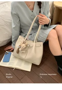 Sac cabas minimaliste en cuir crème avec breloque ours dans un cadre de vie douillet