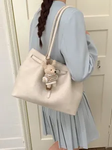 Sac cabas élégant en cuir souple blanc cassé avec ceinture et breloque ours pour le travail.
