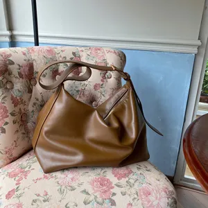 Large brown slouchy shoulder bag in soft leather with minimalist hobo style design.