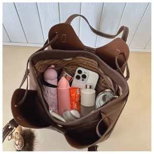 Internal view of a large capacity brown tote bag showing organized daily essentials.