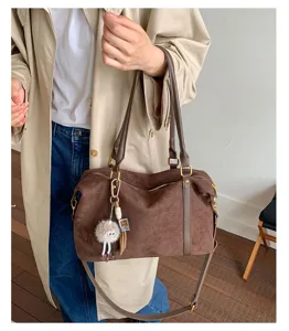 Classic brown suede Boston bag featuring a stylish commute look with a cute pendant