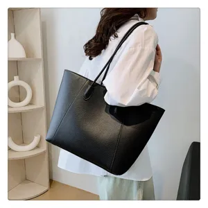Modella con borsa tote nera in pelle martellata in un ambiente d'interni moderno