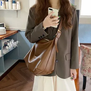 Large capacity brown soft leather commuter shoulder bag shown in lifestyle setting