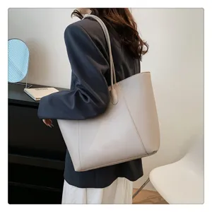 Borsa tote grigia minimalista da donna per ufficio, borsa a spalla grande indossata.