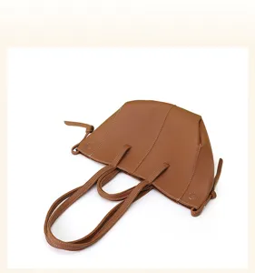 Detailed view of brown vintage wing tote bag with pebbled texture and white stitching.