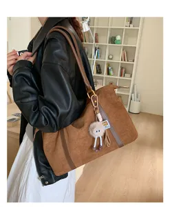 Retro brown suede bowling bag with large capacity and cute fuzzy charm for women.