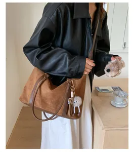 Model carrying a retro brown suede Boston bag in a cozy indoor lifestyle setting
