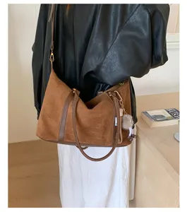 Detailed view of the large brown retro bowling bag being worn as a stylish shoulder bag