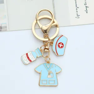Detailed view of medical nurse themed keychain with light blue enamel hat and scrub charms