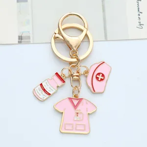 Close-up of pink nurse-themed metal keychain with hat and scrub charms