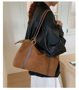 Large brown suede bowling bag worn over the shoulder for a retro commuter look
