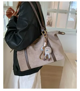 Stylish retro suede bowling bag featuring a large capacity and cute fuzzy mascot keychain