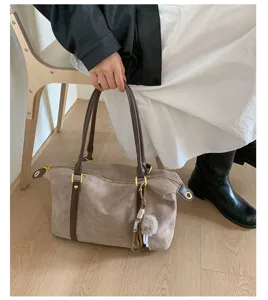Vintage suede bowling bag with large capacity and brown handles shown held by a model