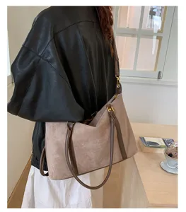 Detailed view of the large vintage bowling bag in taupe worn as a stylish shoulder bag