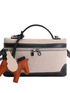 Elegant canvas box crossbody bag with a leather winged horse charm and black trim