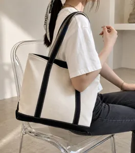 Detailed view of a stylish black and white canvas tote bag carried by a female model