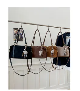 Detailed view of four vintage suede bowling bags hanging on a rack in multiple colors