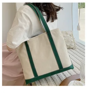 Close-up detail of a stylish large capacity canvas tote bag with green straps and trim