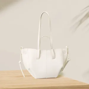 Minimalist cream white wing-shaped tote bag with lychee grain leather on wooden table