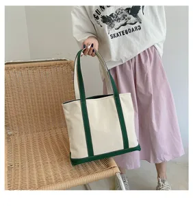 Large capacity cream canvas tote bag with green trim shown in a casual lifestyle setting