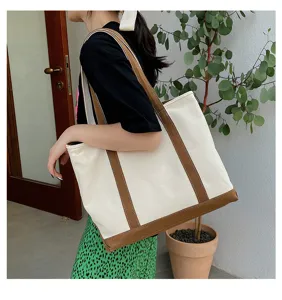 Casual large-capacity canvas tote bag with brown trim carried by a woman in a lifestyle setting