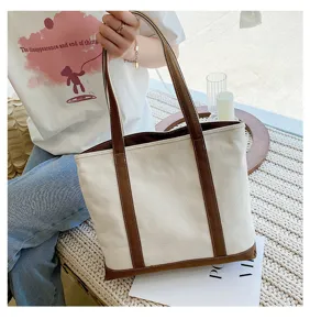 Large capacity canvas tote bag with brown straps styled on model in casual setting