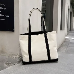 Large minimalist canvas tote bag featuring black straps and base for women's casual fashion