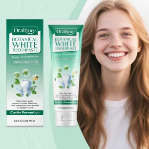 Detailansicht der Oralhoe Botanical White Zahnpasta-Verpackung und einer lächelnden Frau.