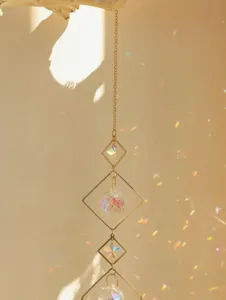 Close-up of geometric crystal suncatcher throwing beautiful rainbow light against a sunlit wall